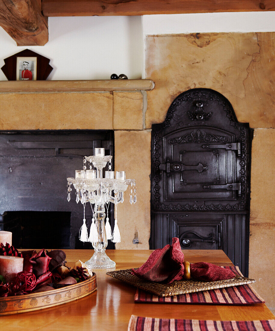 Tischplatte im Esszimmer mit Kamin und altem gusseisernen Ofen in der Wand
