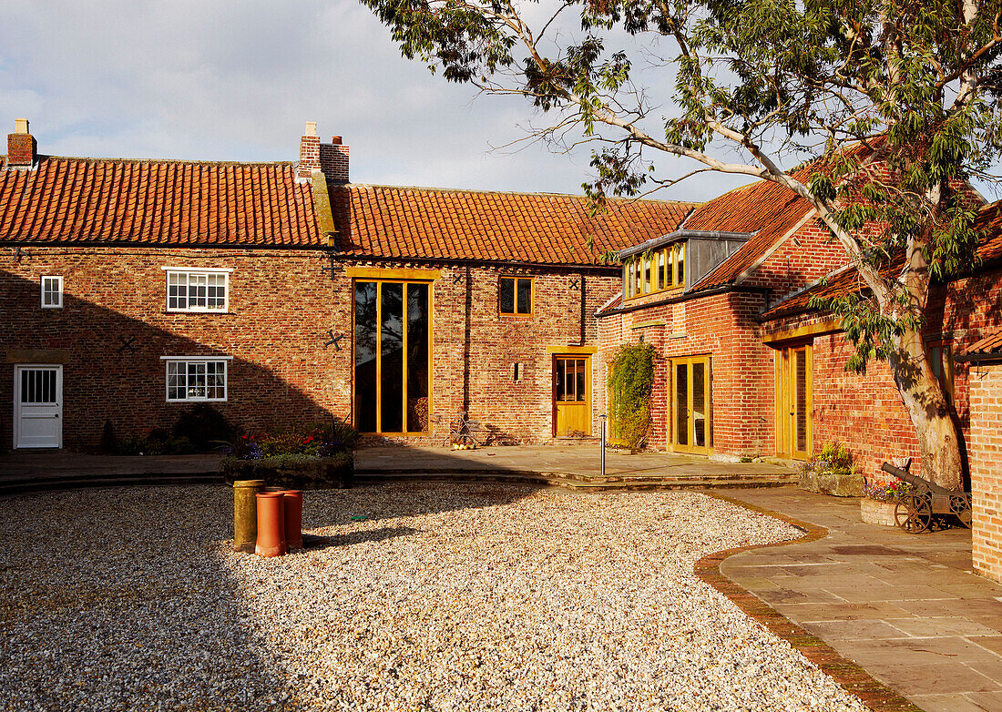 Gravel courtyard and brick exterior of country home