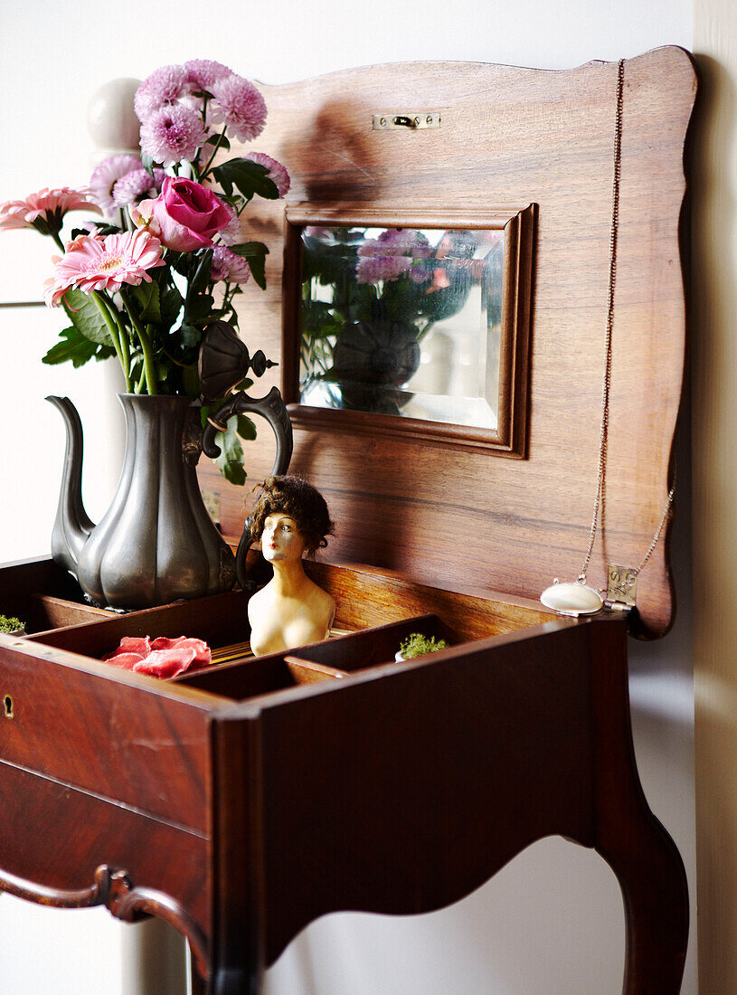 Vase mit Schnittblumen auf antikem Schmucktisch