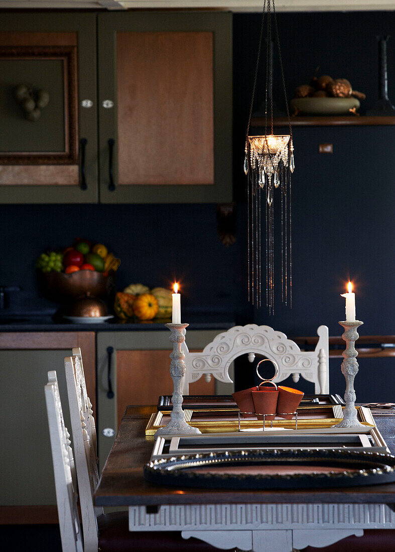 Lit candles on dining table in cottage kitchen