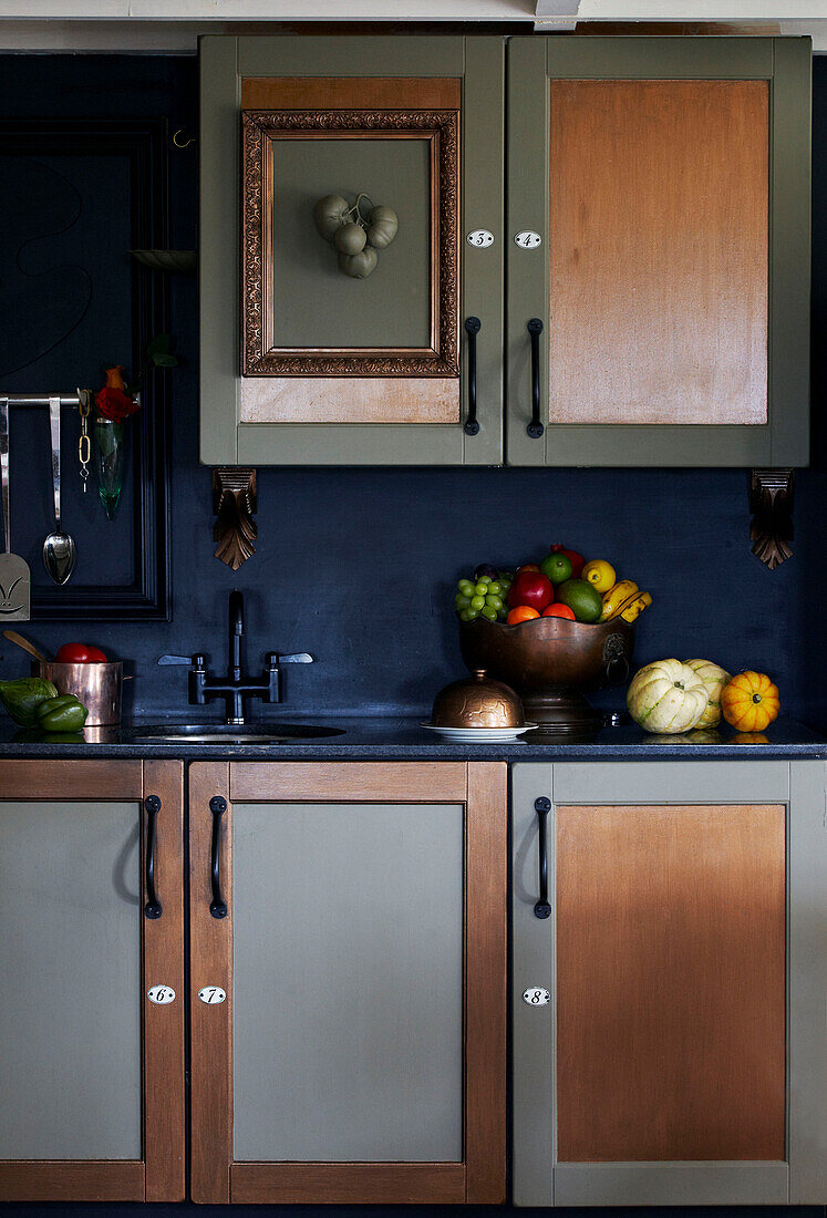 Obstschale und Bilderrahmen in blauer Küche mit gedämpftem Metallic-Finish