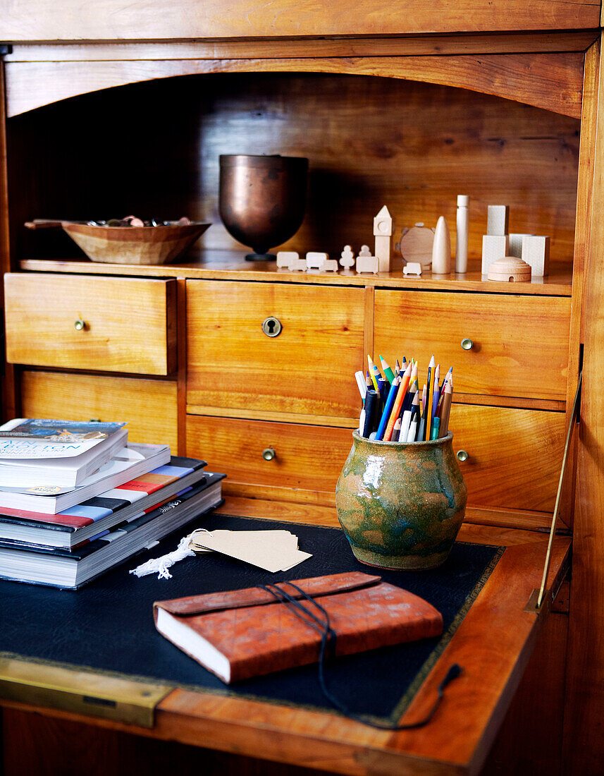 Bleistifte in Halter und Holzschubladen eines Schreibtisches