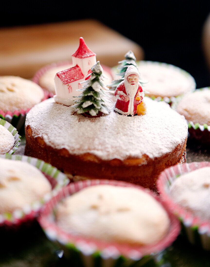 Biskuitkuchen mit Weihnachtsfiguren und Mince Pies mit Puderzucker