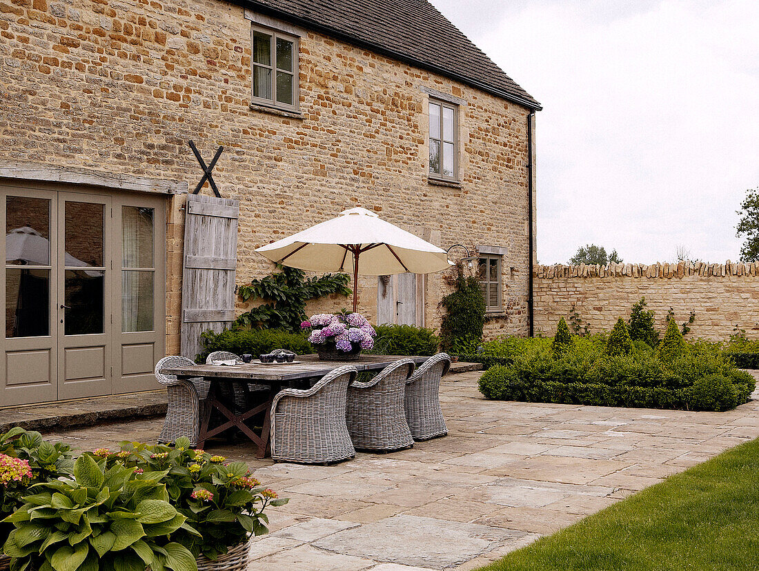 Wicker table and chairs in farmhouse courtyard exterior