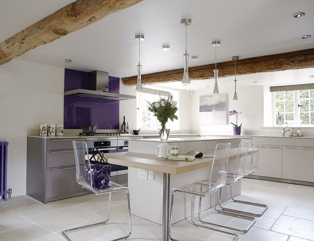 Moderne Küche mit lila Spritzschutz und Frühstücksbar in renoviertem Mühlenhaus in den Cotswolds, England