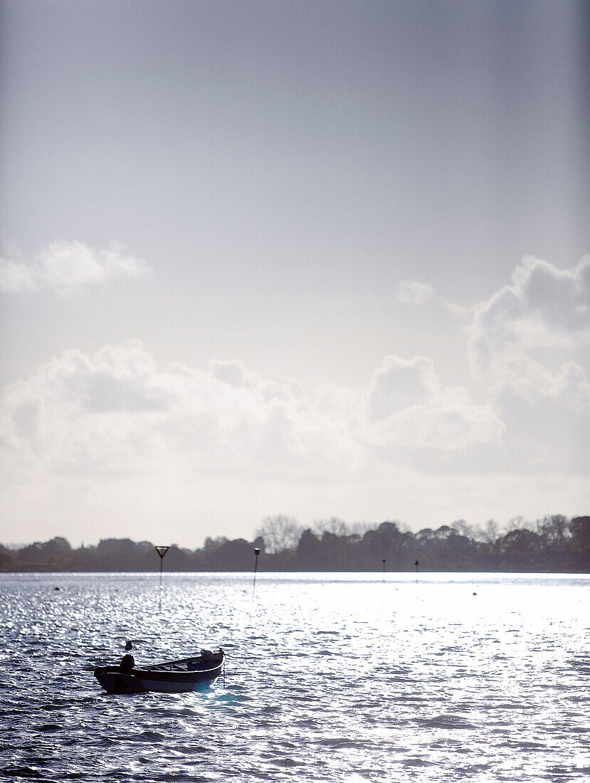 Solitary rowing boat on sparkling water Hampshire home England UK