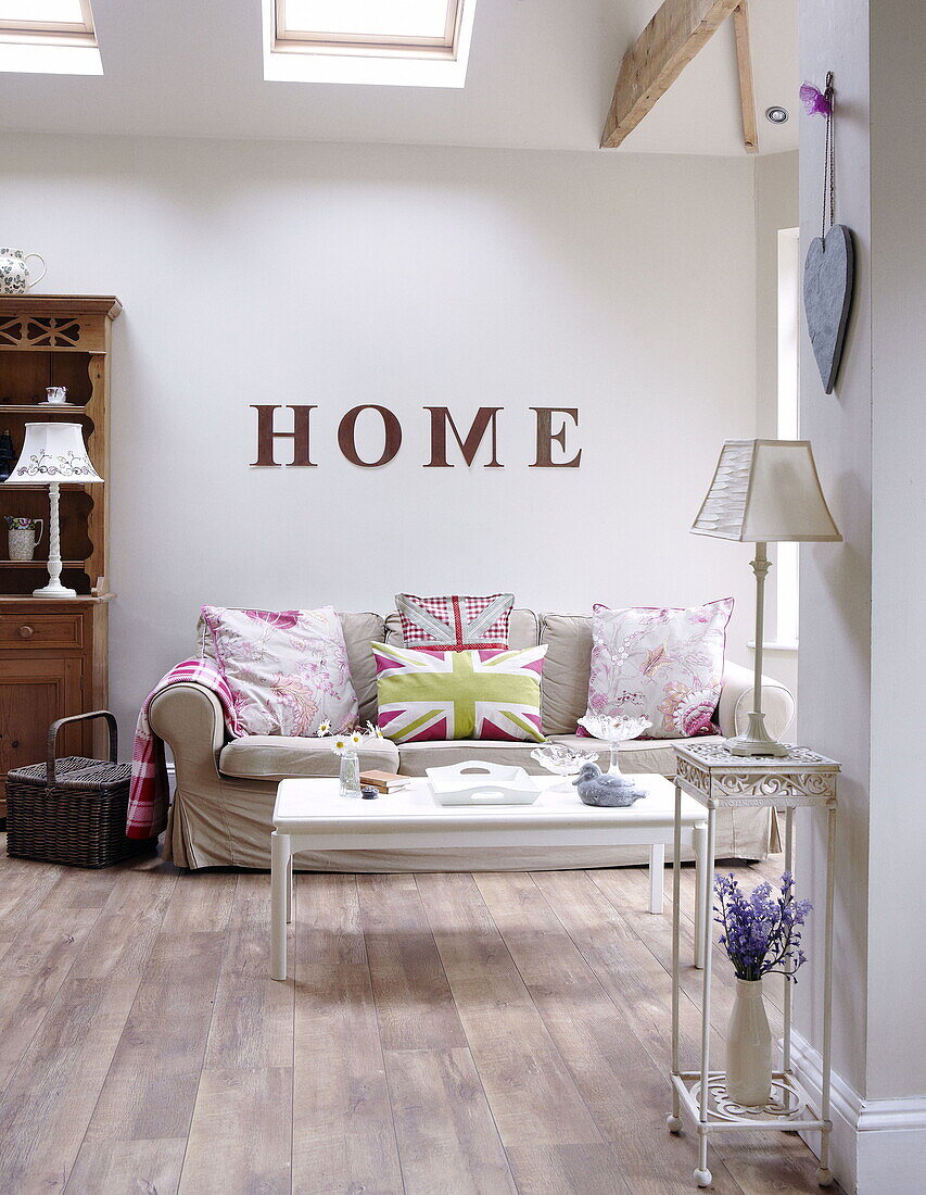 Sofa with cushions below single word 'HOME' in living room of Gateshead apartment Tyne and Wear England UK