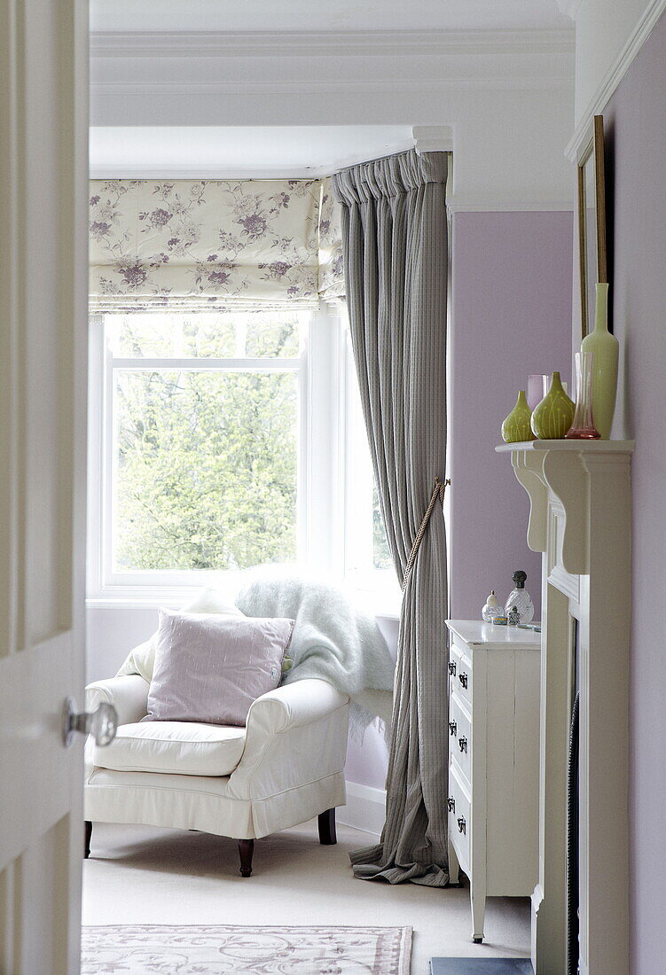 Armchair at window of bedroom in Harrogate home Yorkshire England UK