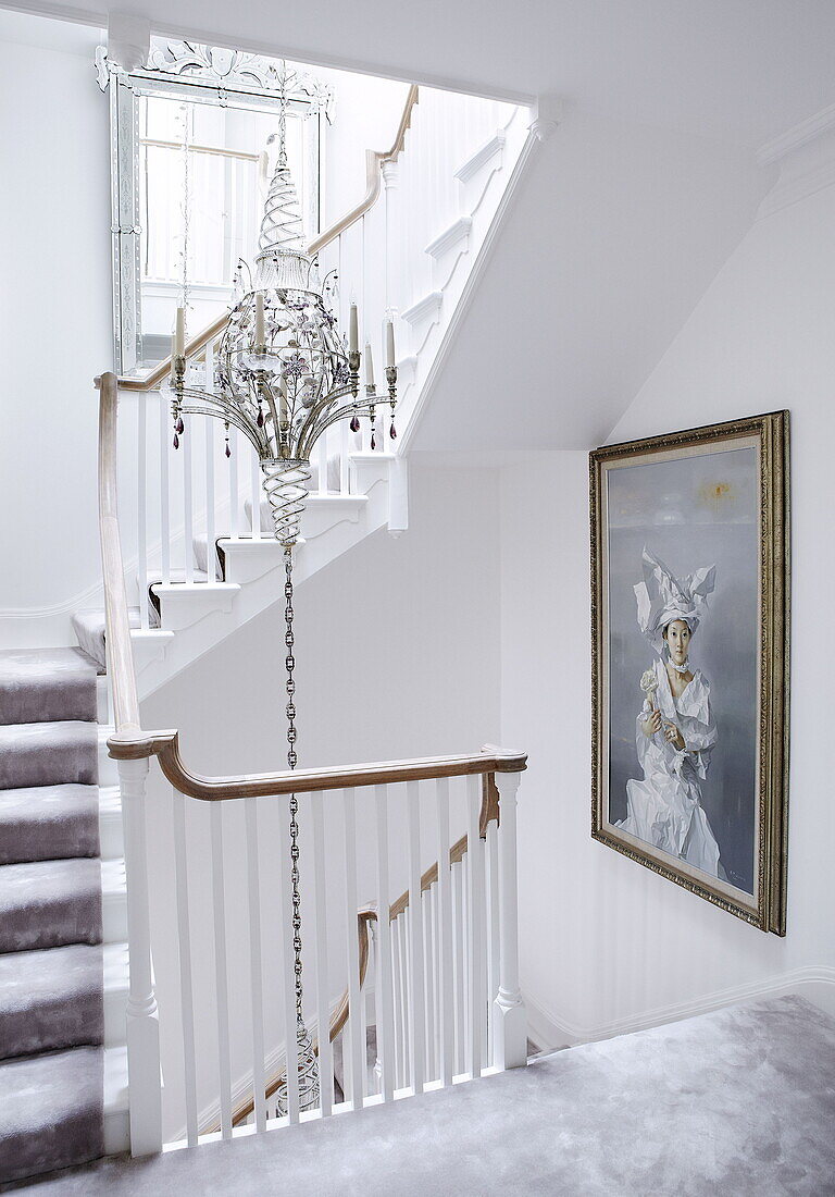 Kandelaber und Kunstwerke im weißen Treppenhaus eines Londoner Hauses, UK