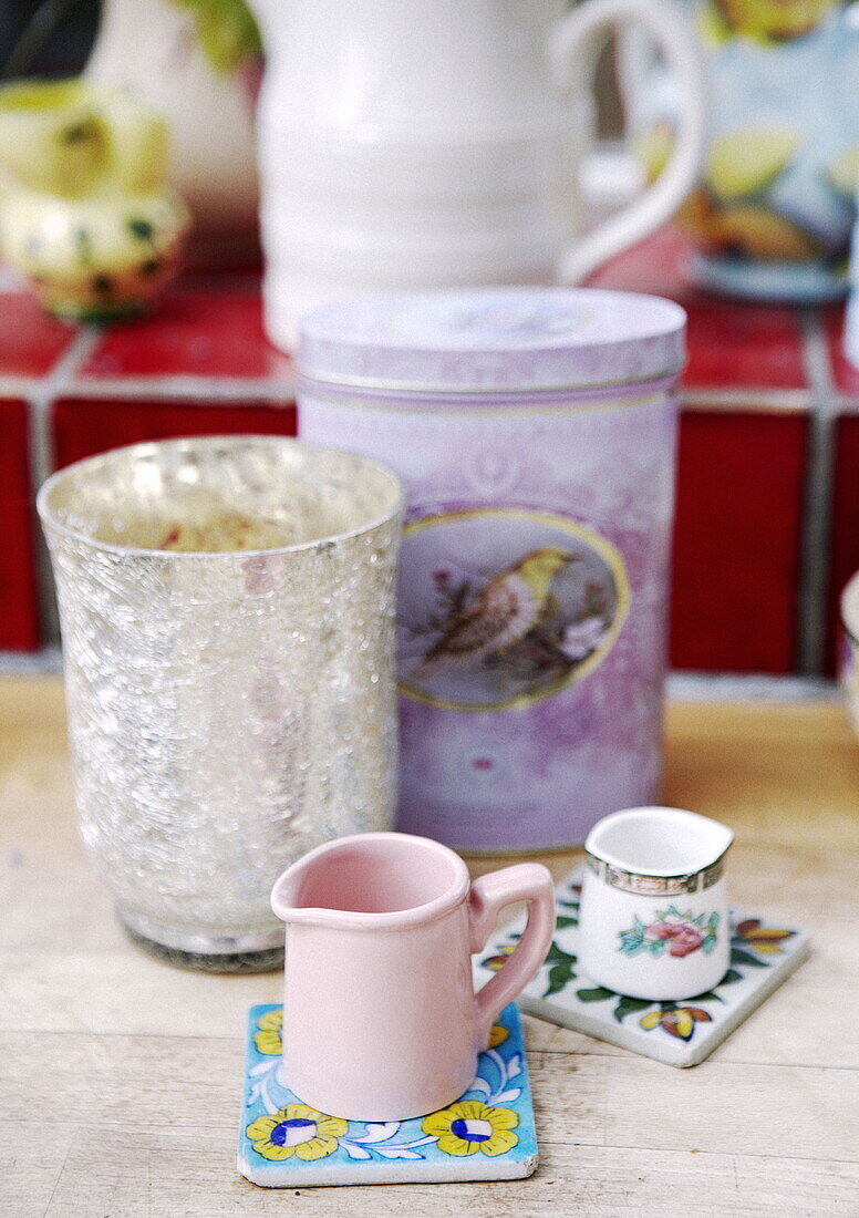 Silberne Vase und Vorratsdose mit Milchkännchen auf Untersetzern in einem Londoner Haus UK