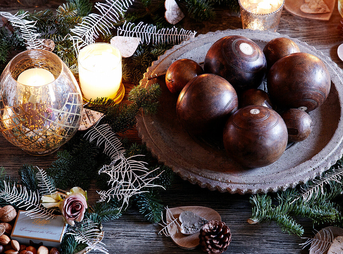 Antique bowling balls and lit candles on tabletop in festive Oxfordshire home, England, UK