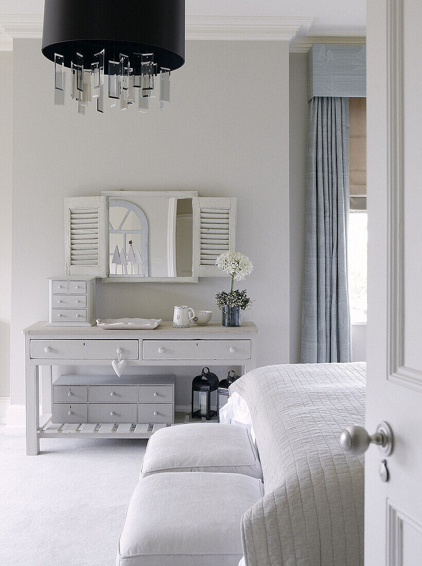 Salvaged mirror with shutters above console table in bedroom of country house inTunbridge Wells Kent England UK