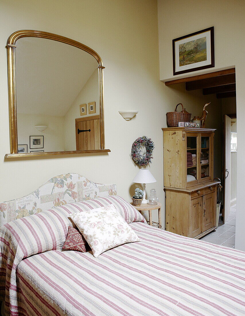 Vergoldeter Spiegel über einem Doppelbett in einem Landhaus in Hexham, Northumberland, England, UK