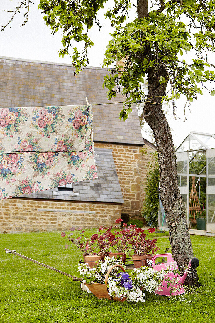 Floraler Stoff hängt an der Wäscheleine im Garten eines Hauses in Oxfordshire, England, Vereinigtes Königreich