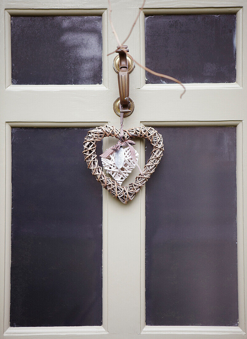 Herzförmiger Weihnachtsschmuck an der Haustür eines Hauses in Oxfordshire, England, Vereinigtes Königreich