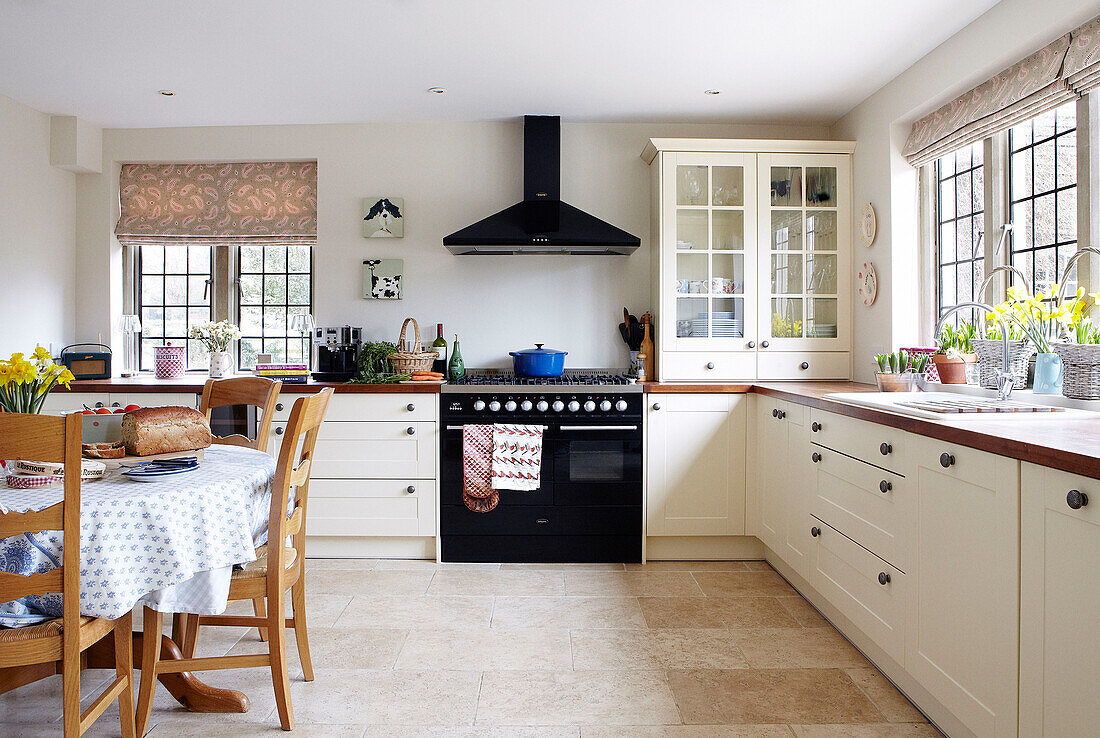 Auflaufform auf Gaskochfeld mit schwarzem Ofen in einer Küche in Oxfordshire, England, Vereinigtes Königreich