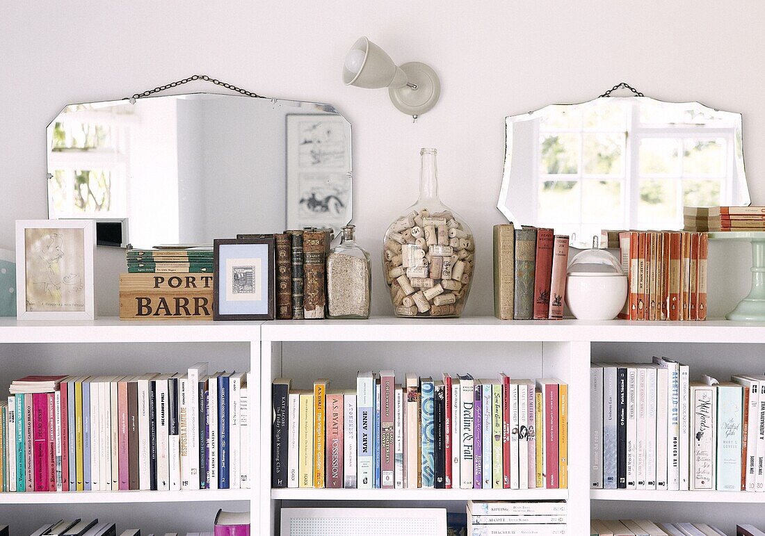 Vintage mirrors above bookcase in Staffordshire home, England, UK