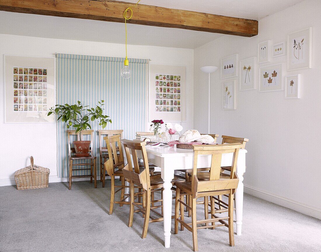 Dining table with pew chairs under ceiling beam of contemporary Staffordshire cottage, England, UK