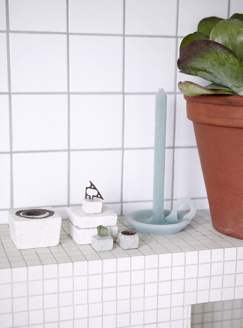 Houseplant and ornaments with candle in tiled bathroom in Bussum home, Netherlands