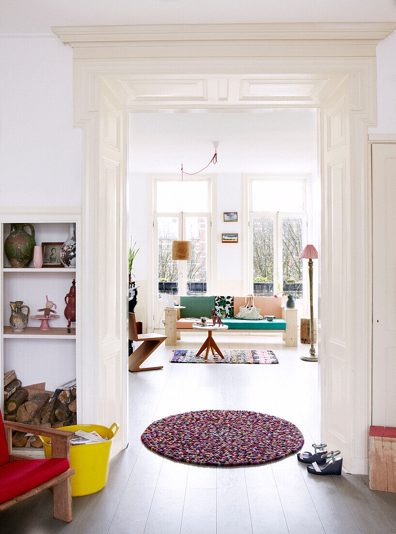 Blick durch eine Tür mit kreisförmiger Fußmatte in einer luftigen Wohnung in Amsterdam, Niederlande