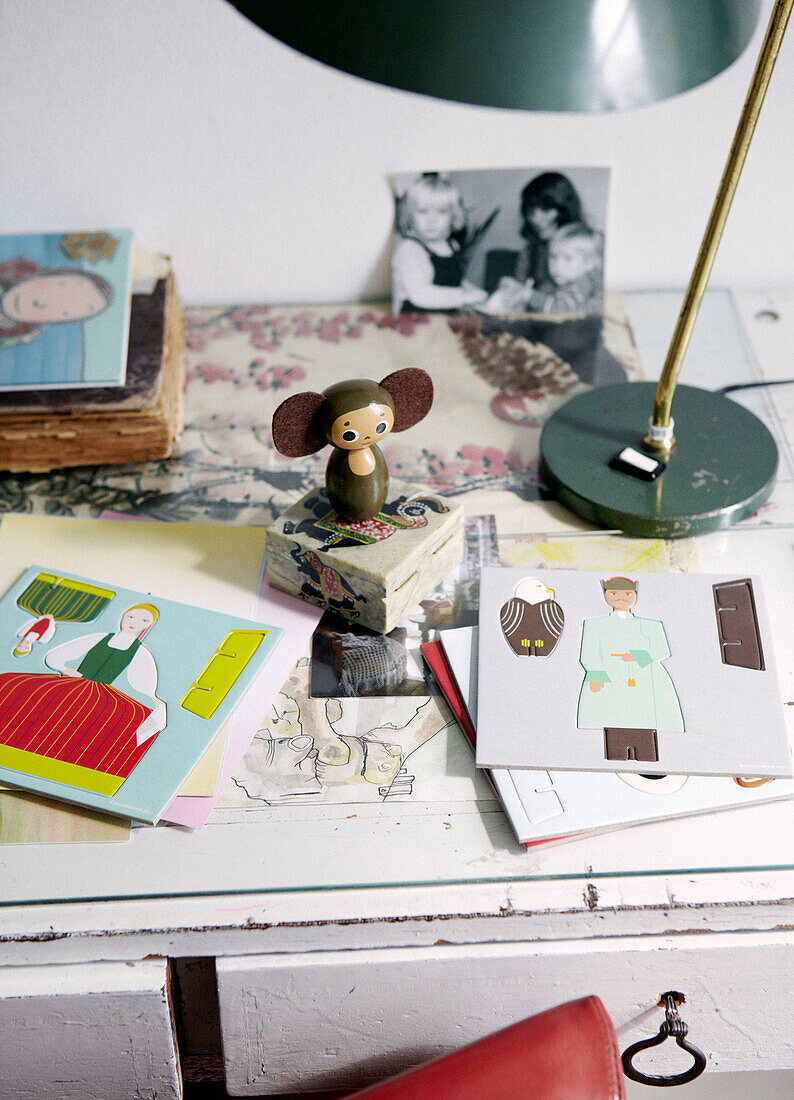 Ausgeschnittenes Buch mit Mausfigur und Familienfoto auf dem Schreibtisch in einer modernen Wohnung, Amsterdam, Niederlande