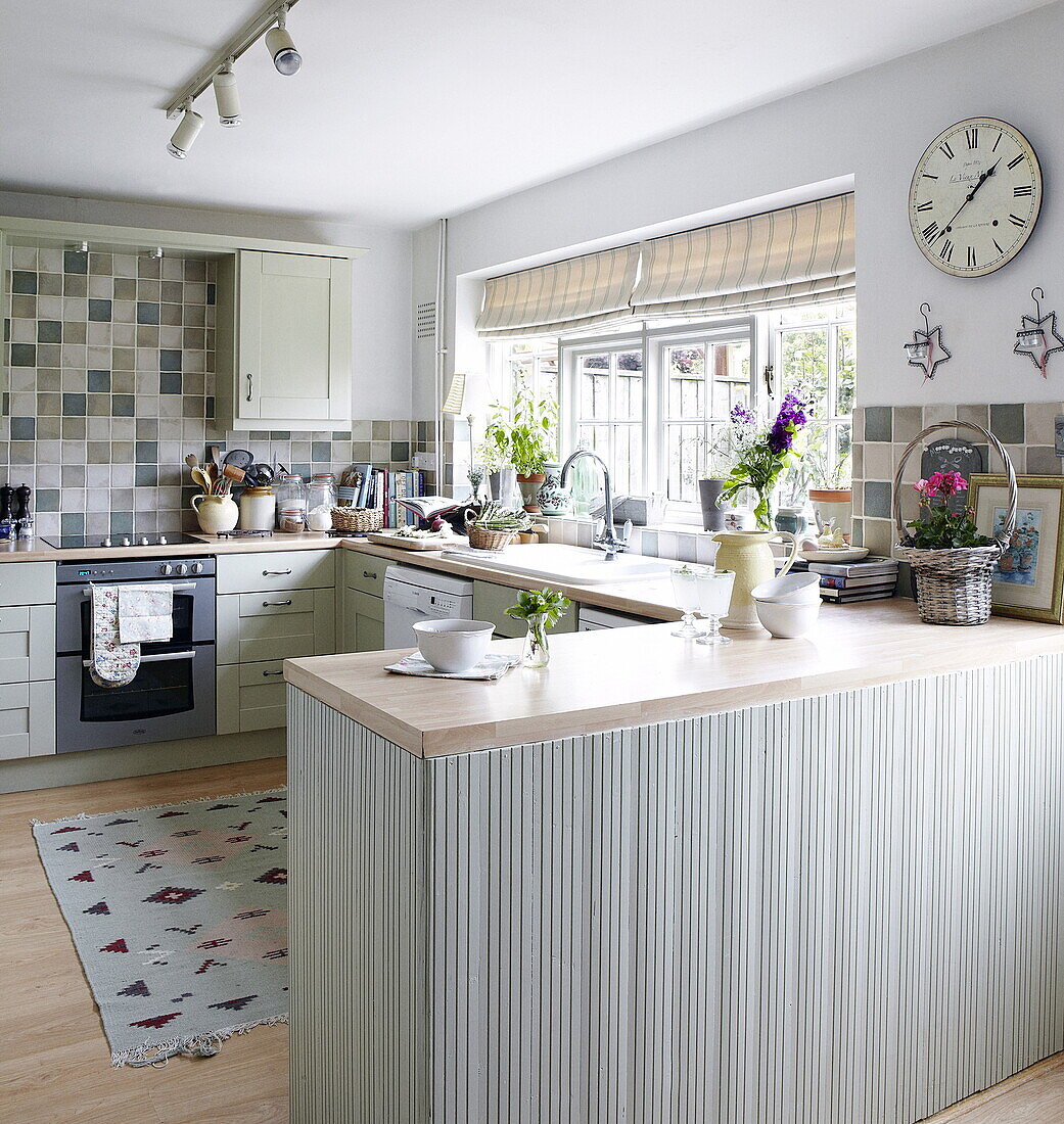 Green tiled farmhouse kitchen with wooden worktops, Oxfordshire, England, UK