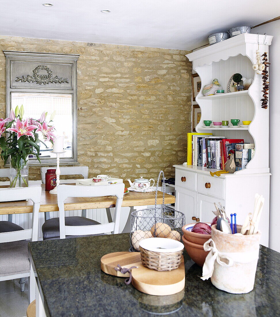 Offene Küche mit freiliegender Steinmauer und bemalter Küchenkommode in Oxfordshire, England, UK
