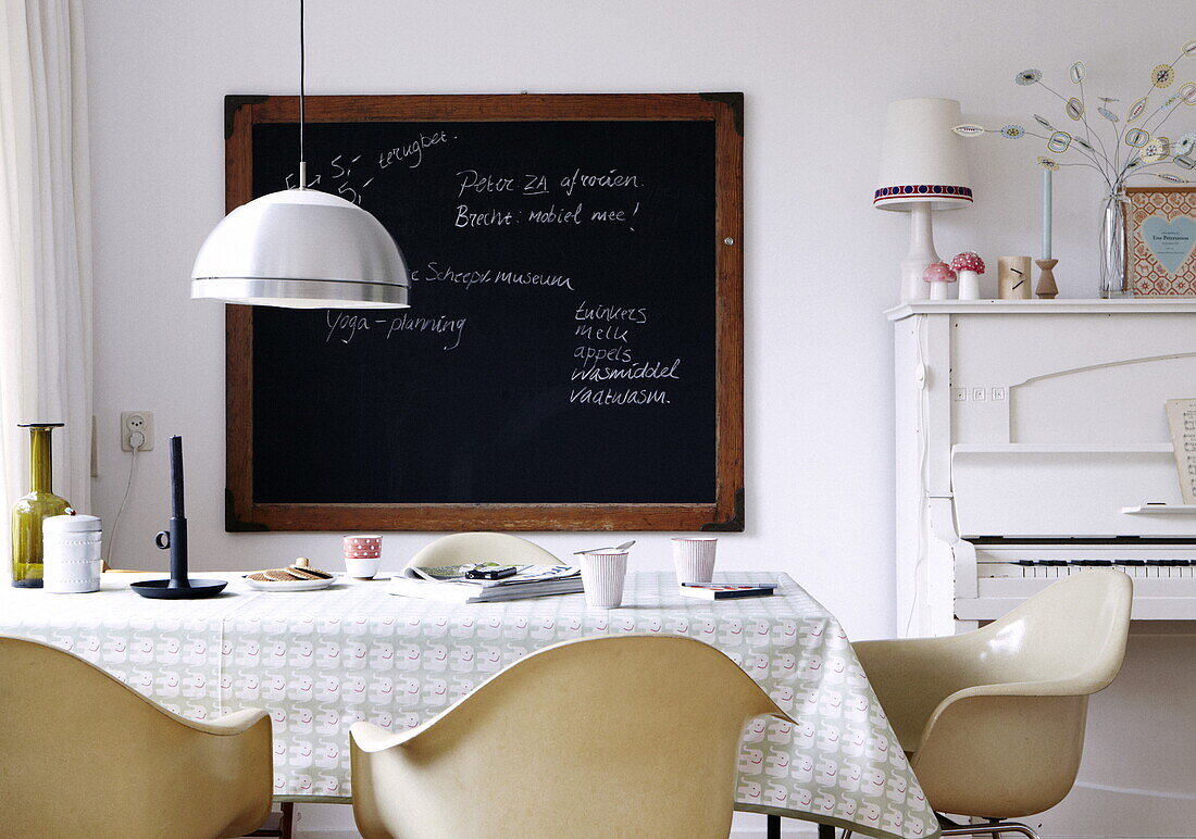 Küche im Retrostil mit Tafel, Klavier und Metallpendelleuchte in einem Haus in Bussum, Niederlande