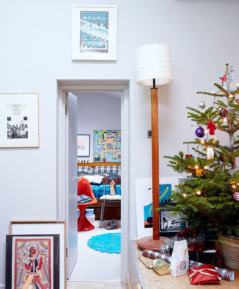 Weihnachtsbaum und Lampe mit Blick durch die Tür zum Schlafzimmer eines Londoner Familienhauses England UK