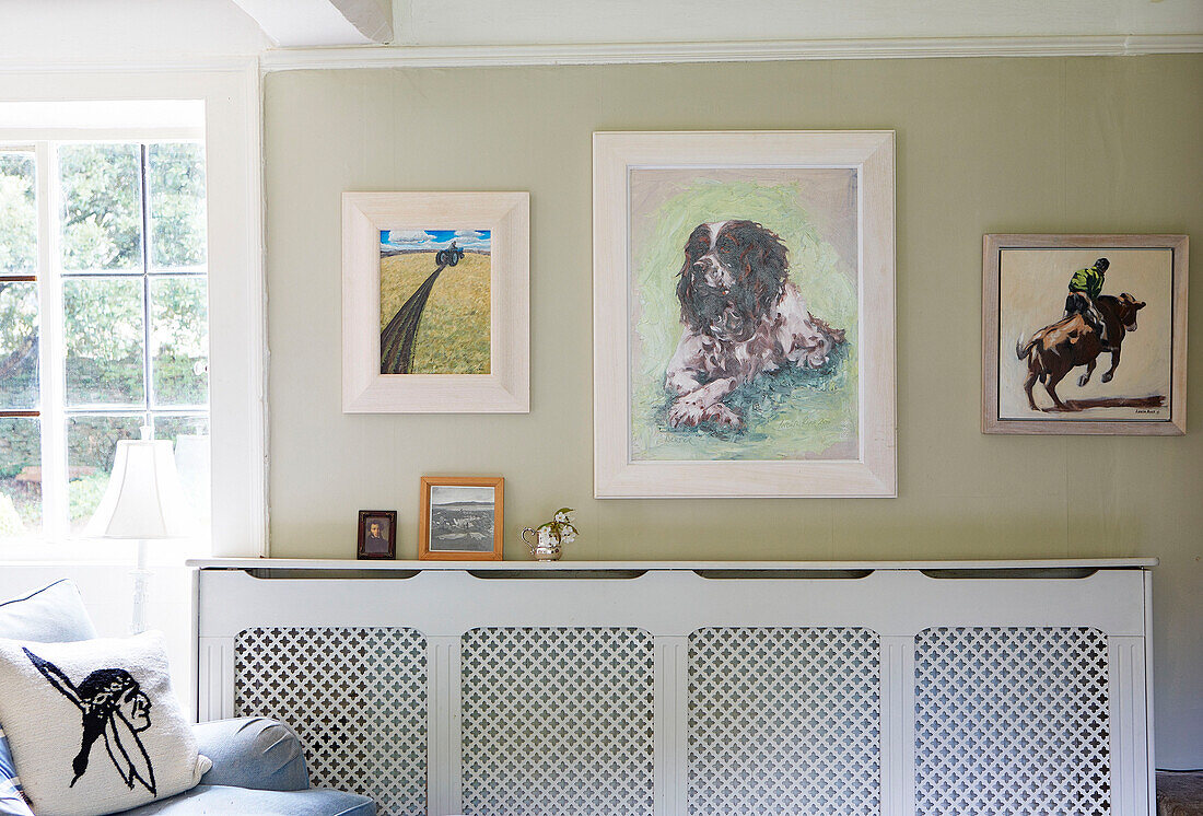 Heizkörperabdeckung und Kunstwerk im Wohnzimmer eines Bauernhauses in Oxfordshire England UK