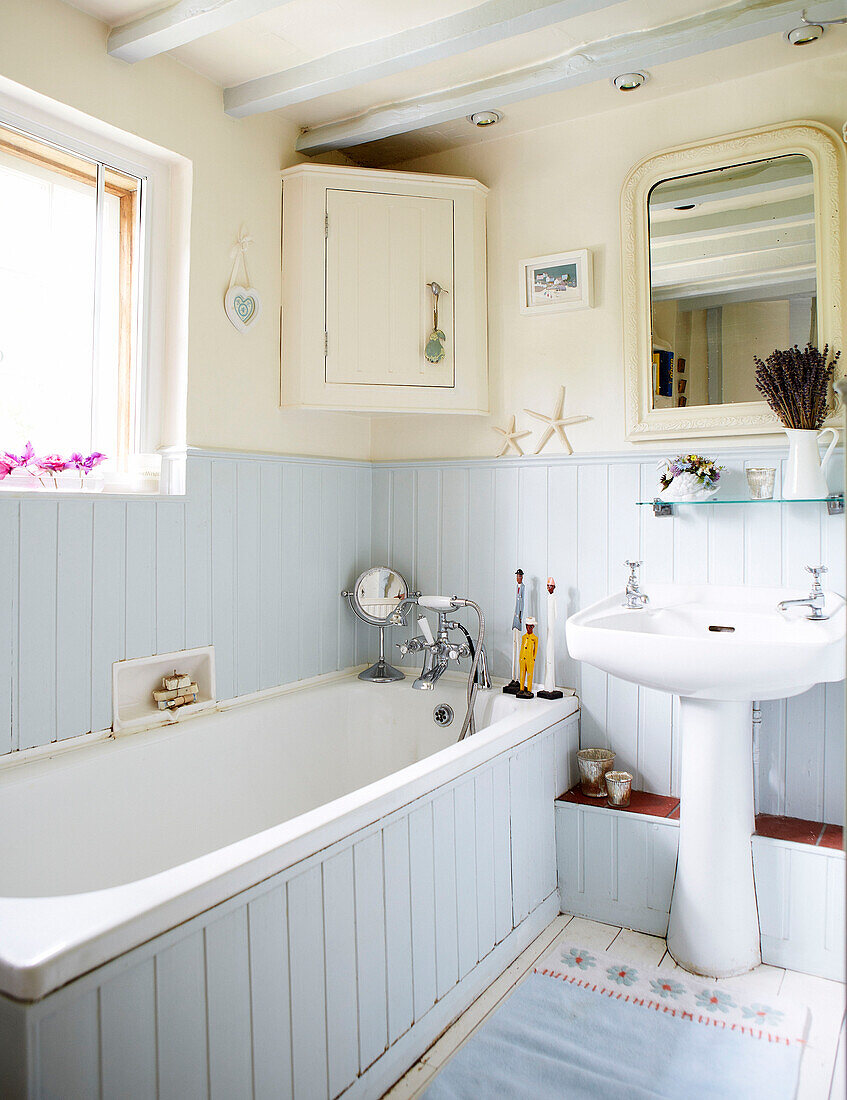 Hellblau und cremefarben getäfeltes Badezimmer in einem Bauernhaus in Surrey England UK