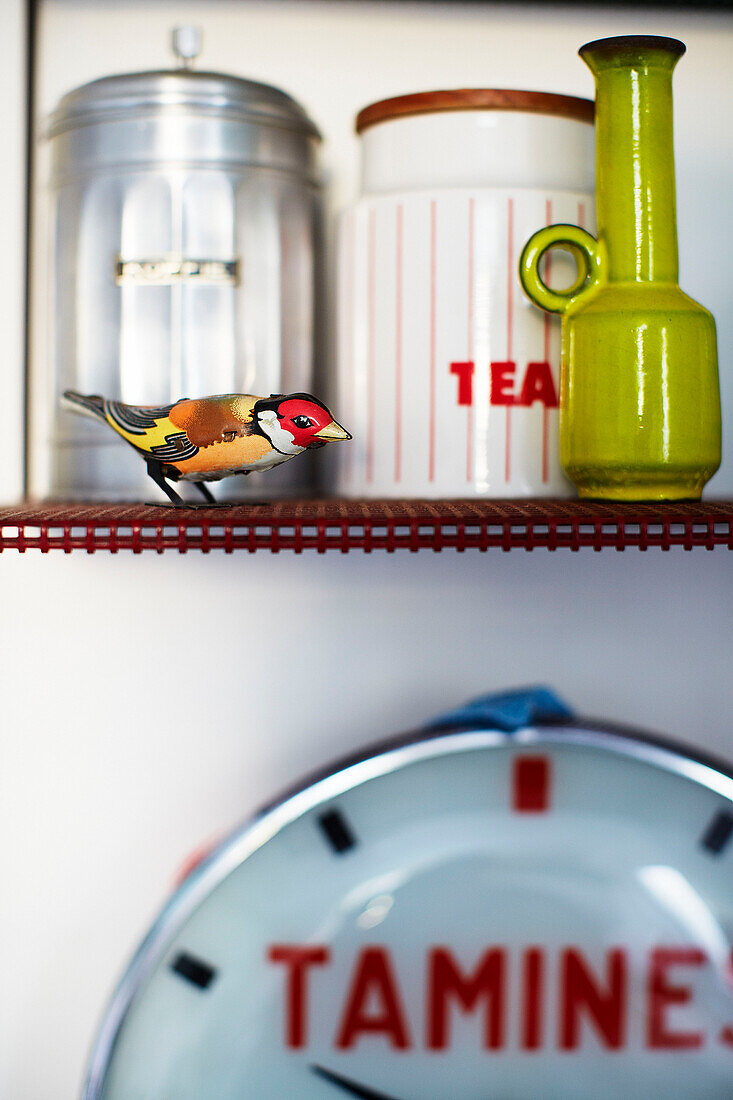 Painted bird and storage tins on kitchen shelf in family home in Margate Kent England UK