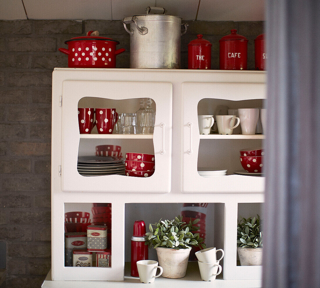 Kitchen dresser with red and white crockery in brittany schoolhouse conversion France