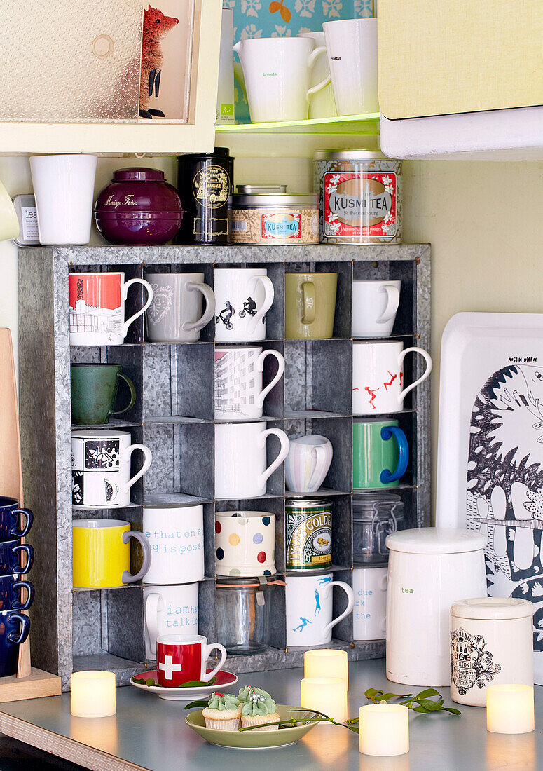 Verschiedene Tassen in einem Metallregal in der Küche eines Londoner Familienhauses England UK