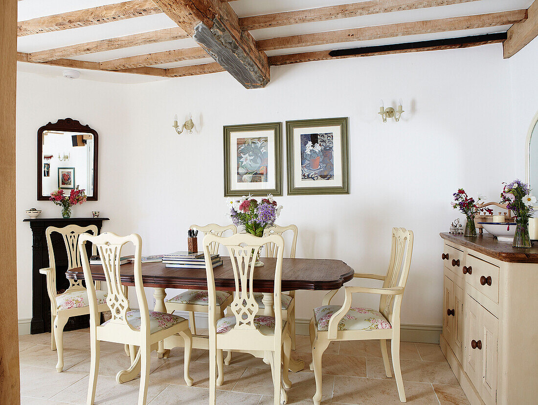 Esstisch mit bemalten Stühlen in einem Cottage mit Balken in Oxfordshire, England UK