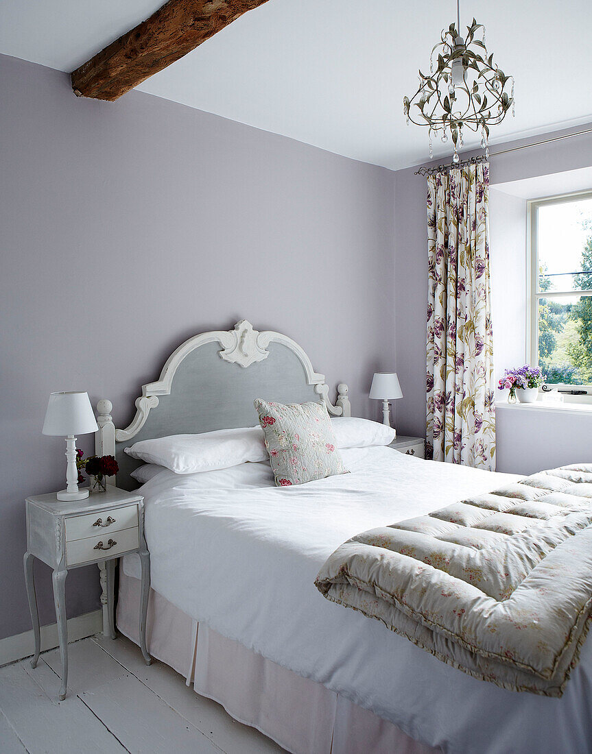 Fliederfarbenes Schlafzimmer mit klassischem Kopfteil und gefalteter Bettdecke in einem Cottage in Oxfordshire England UK