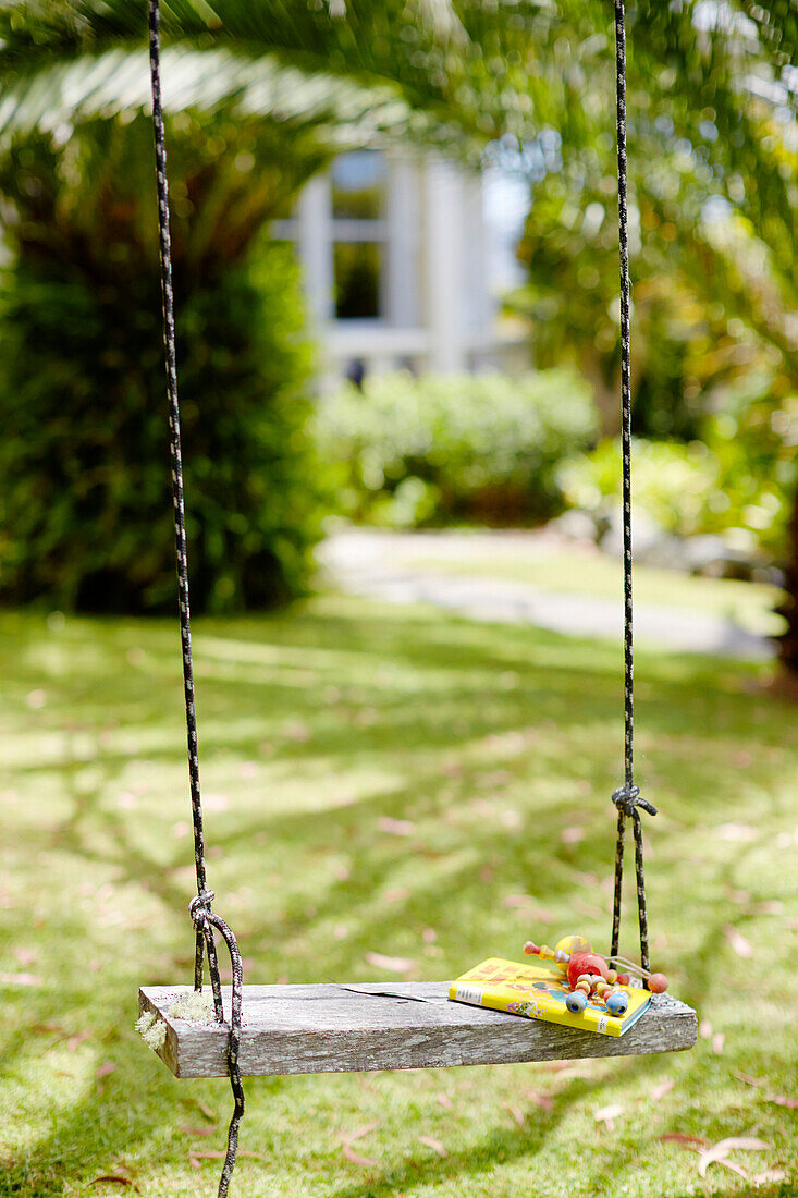 Story book and toy on tree swing in Warkworth garden Auckland North Island New Zealand