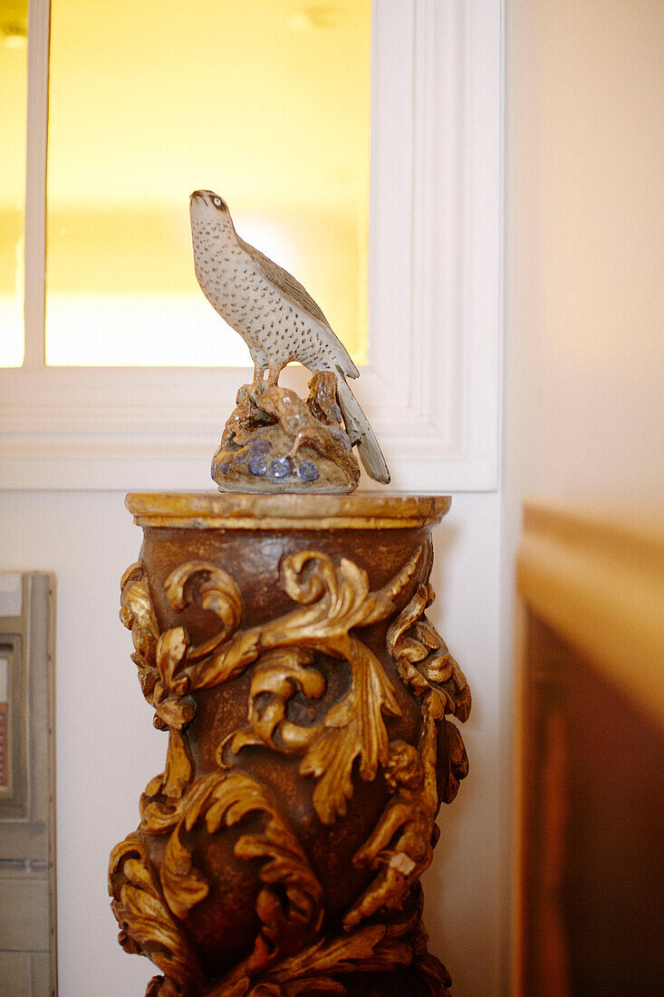 Vogelstatue auf geschnitzter antiker Säule in einem Haus in Notting Hill, West London UK