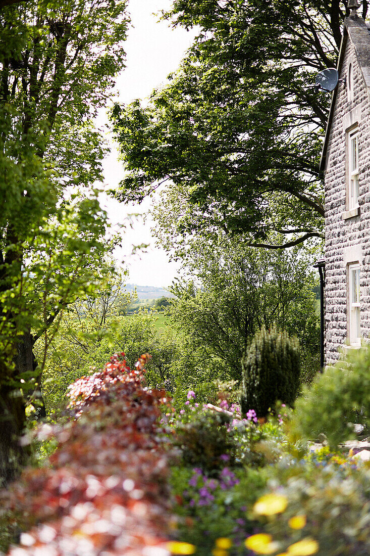 Ländliches Bauernhaus aus Stein in Gartenanlage in Derbyshire England UK