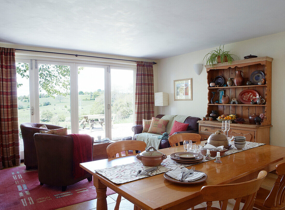 Esstisch und Kommode aus Holz im offenen Wohnzimmer eines Bauernhauses in Derbyshire, England UK