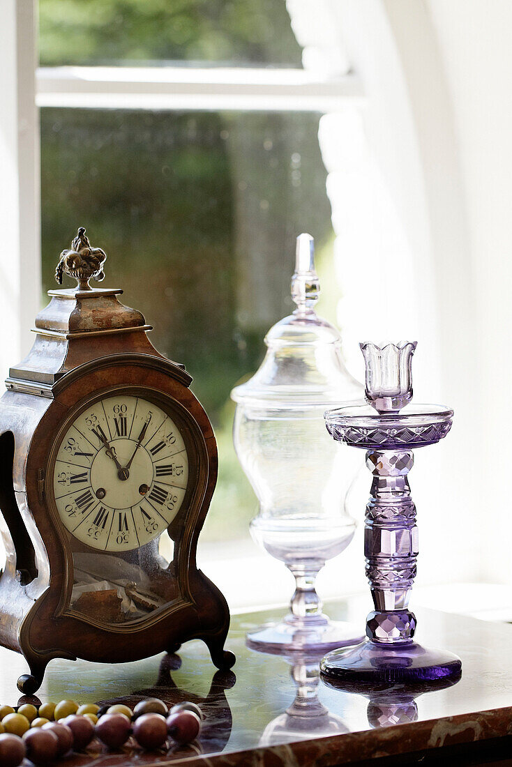 Glaskerzenhalter und Vintage-Uhr auf Anrichte in traditionellem Landhaus Welsh borders UK