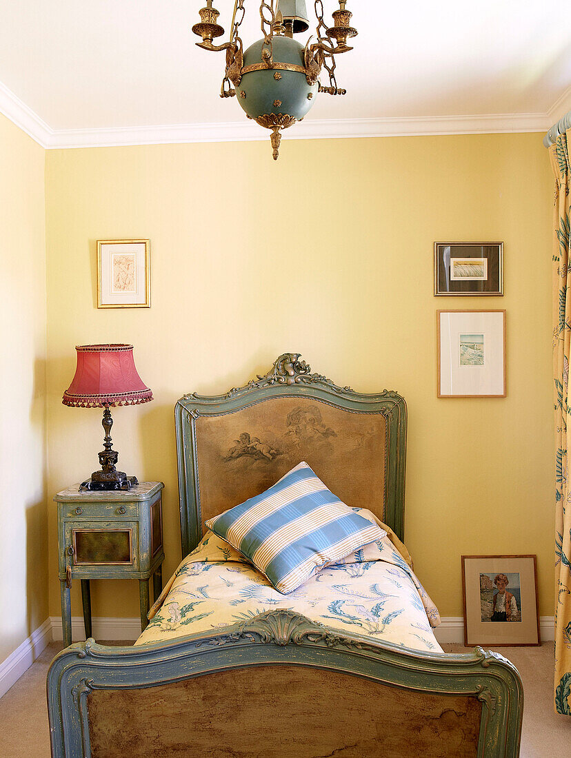 Vintage-Einzelbett im gelben Schlafzimmer eines traditionellen Landhauses an den walisischen Grenzen, Großbritannien