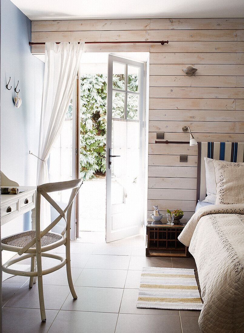 Offene Tür zu einem sonnenbeschienenen Schlafzimmer in einem Gästehaus in der Bretagne, Frankreich