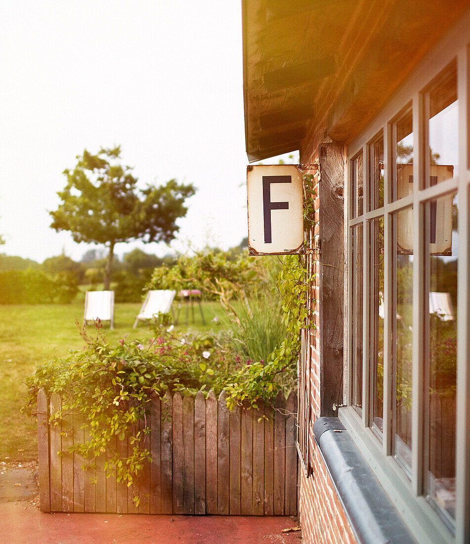 Gartenpavillon und Fenster eines bretonischen Bauernhauses mit entfernten Liegestühlen Frankreich