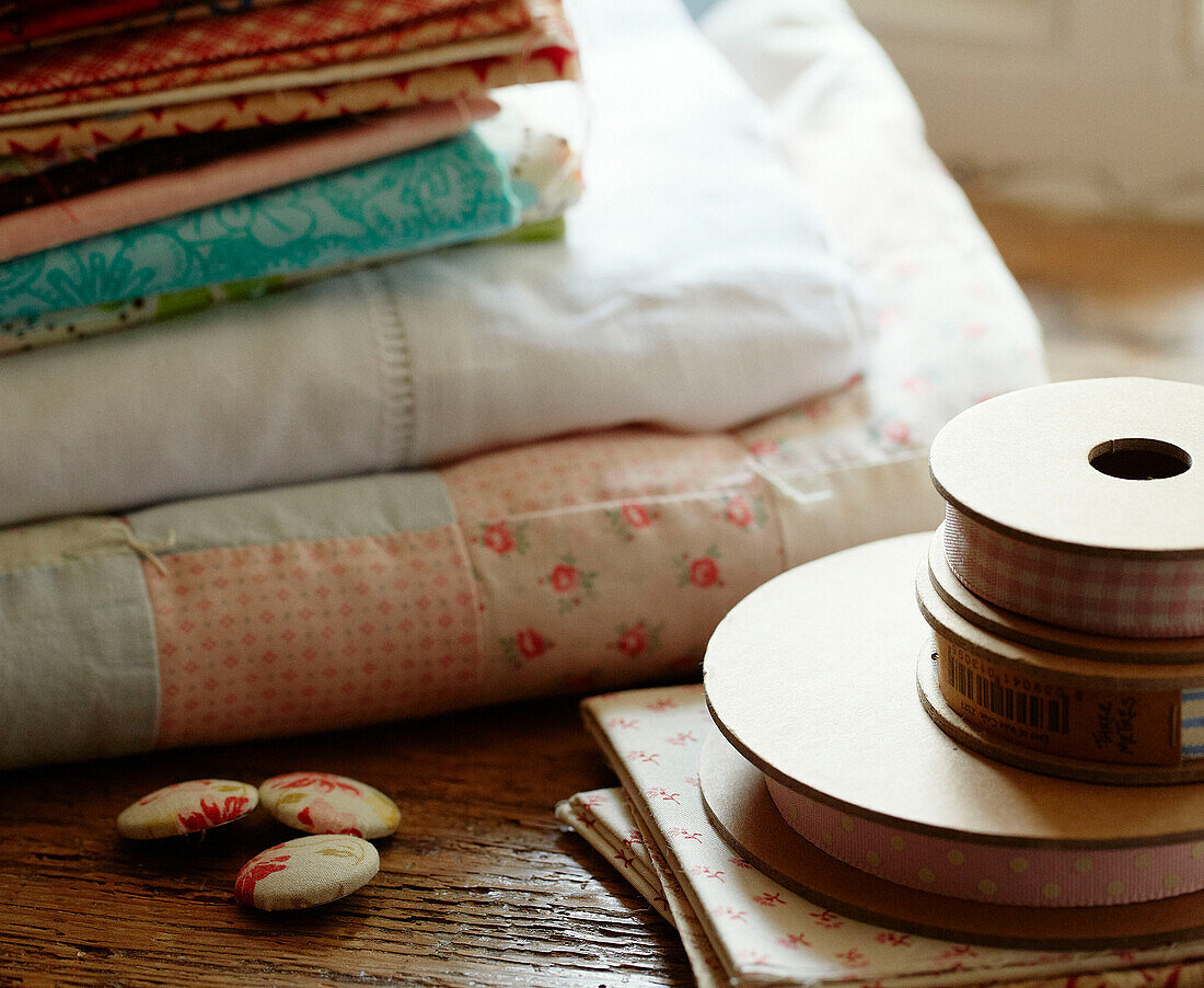 Reels of ribbon and buttons with folded fabrics in Devonshire cottage UK