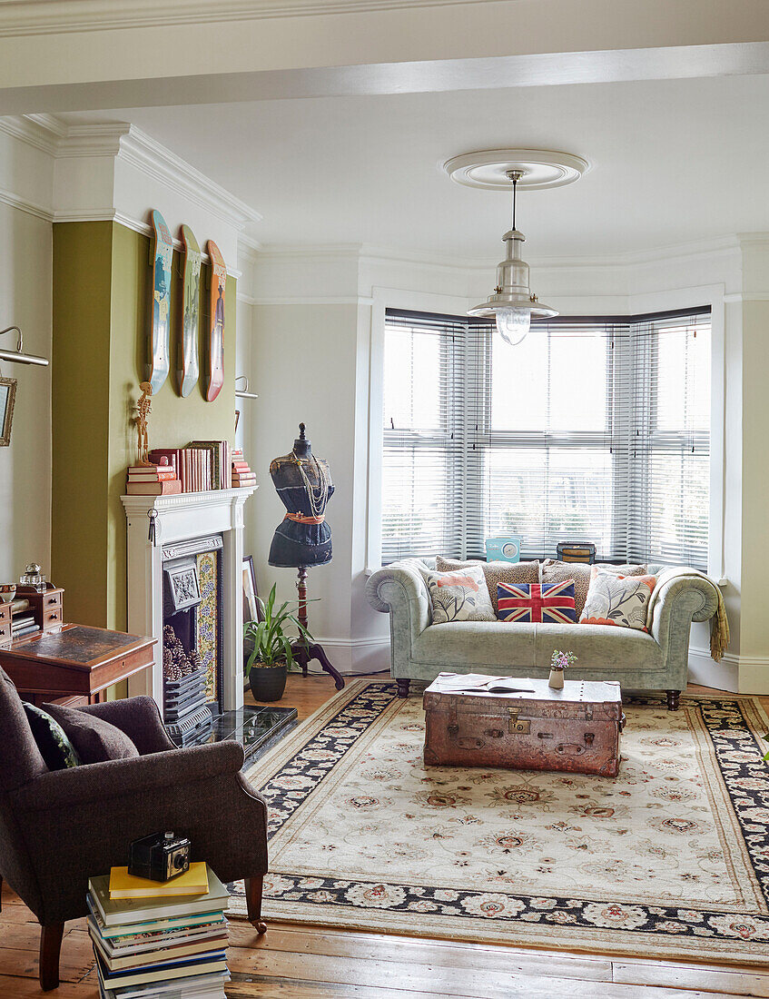 Sofa im Erkerfenster mit Sessel und gemustertem Teppich in einem Wohnzimmer in Kent, England
