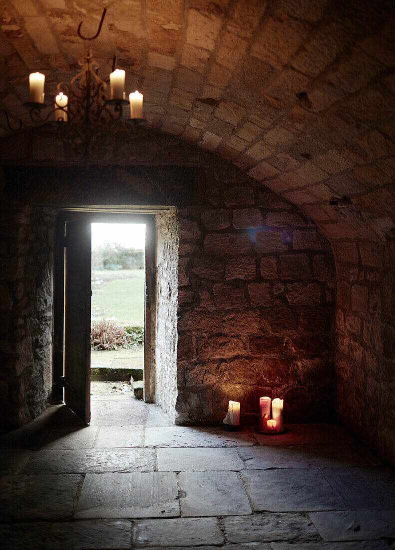Beleuchtete Kerzen in einem gewölbten Steinzimmer eines historischen Herrenhauses in Northumbria, England, UK