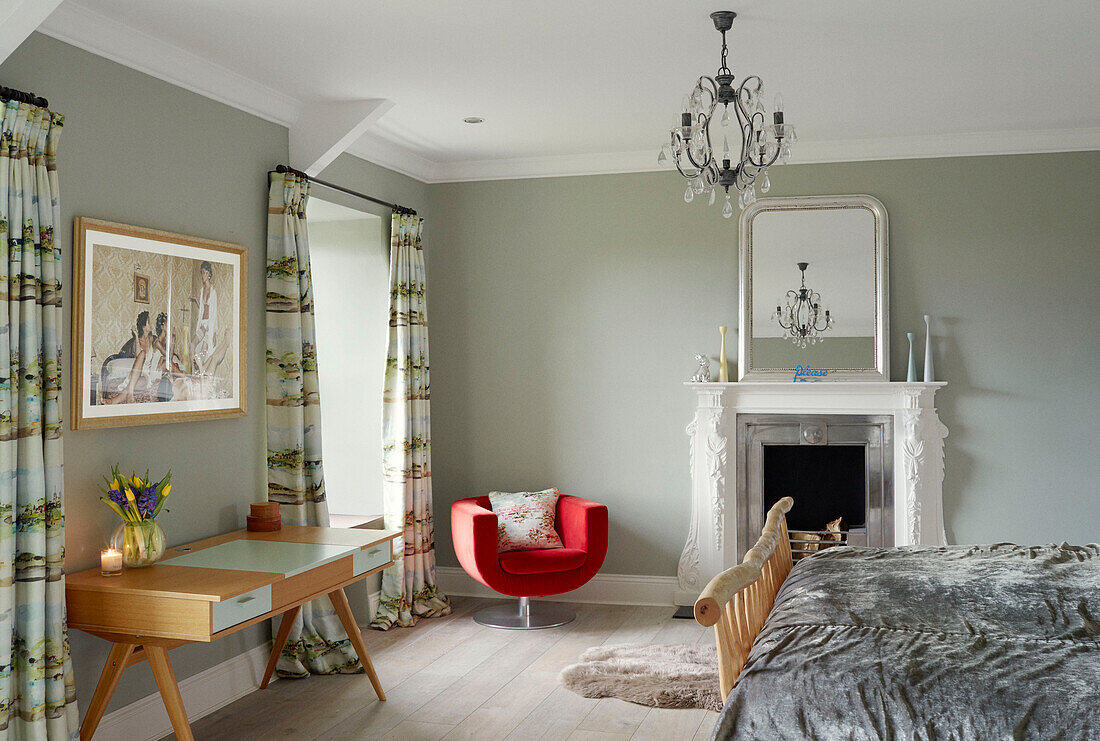Bedroom with chandelier and red chair Northumbrian manor house England UK