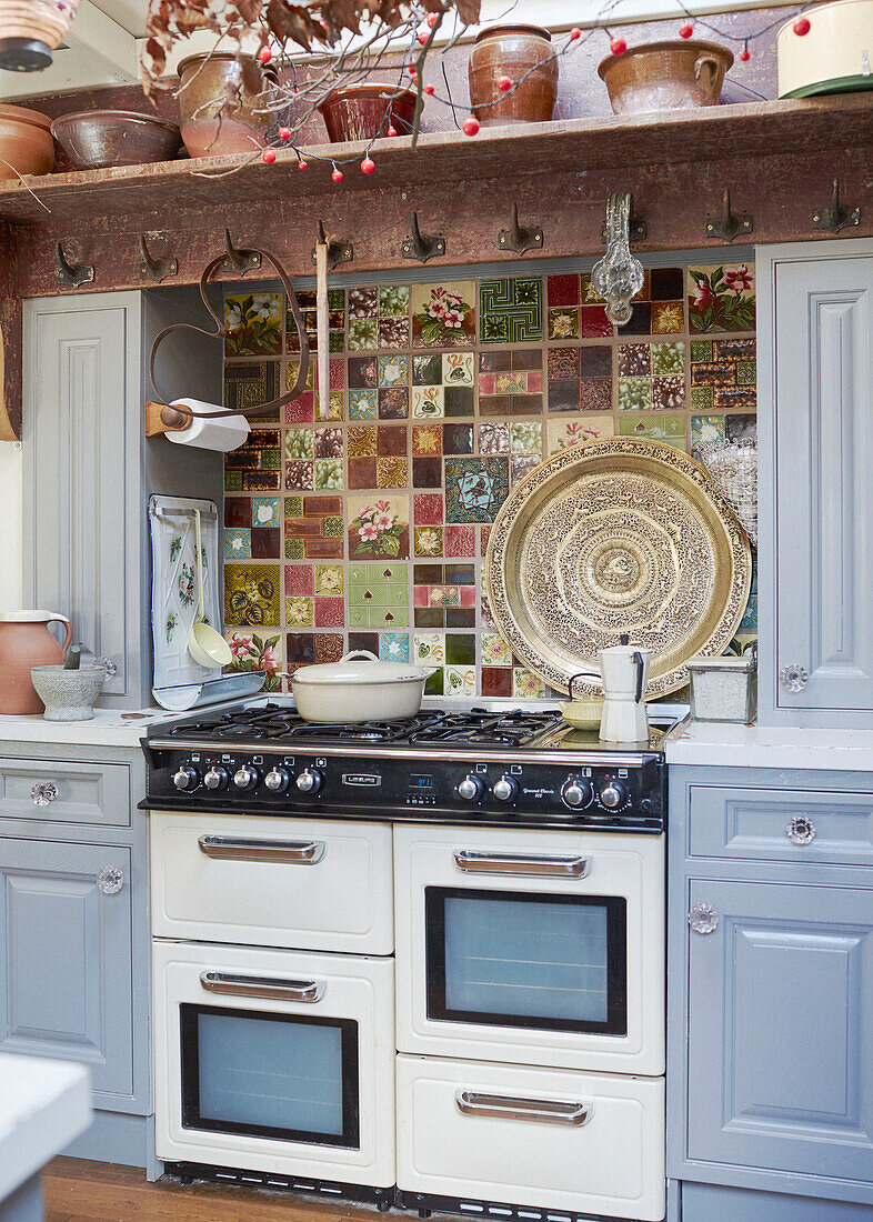 Keramiktöpfe auf einem Regal über einem Gasherd mit gekachelter Rückwand in einer Küche in Whitley Bay Tyne and Wear England UK