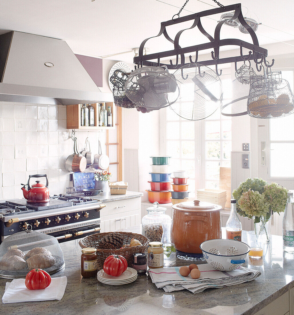 Pan rack above kitchen island in sunlit Brittany guesthouse France